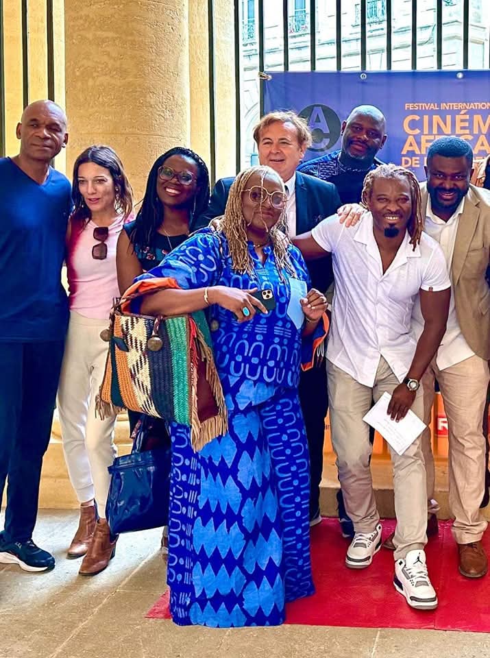 Photo de groupe des invités devant l'affiche