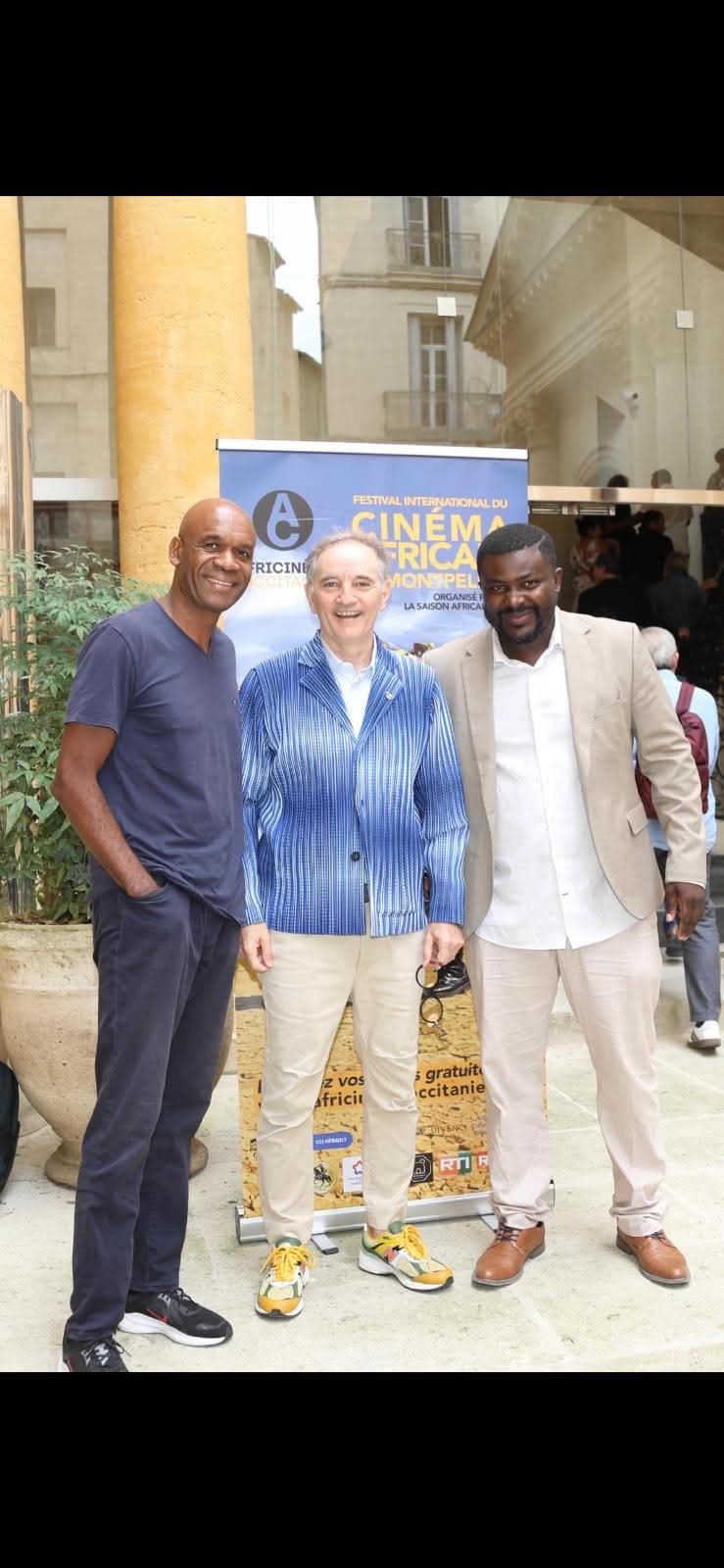 Professionnels et partenaires du festival devant le kakémono Africinéma Occitanie