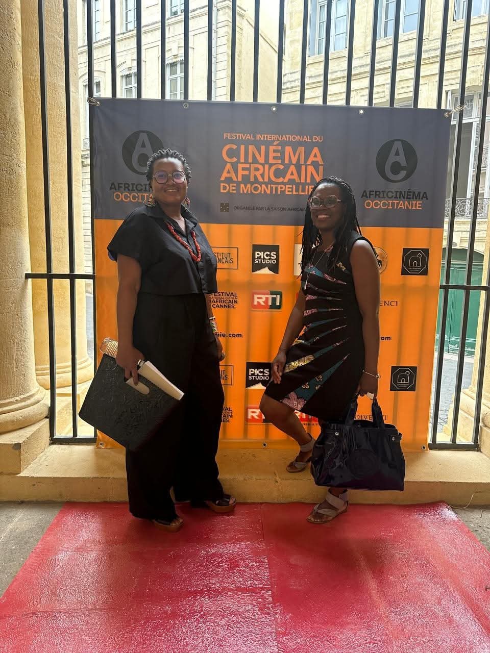 Deux invitées posant sur le tapis rouge devant le photocall du festival